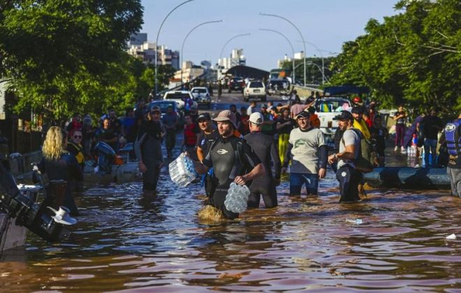 6mai2024 voluntarios caminham por rua alagada na cidade de porto alegre estado do rio grande do sul foi atingido por fortes chuvas nos ultimos dias 1715013764356 v2 900x506